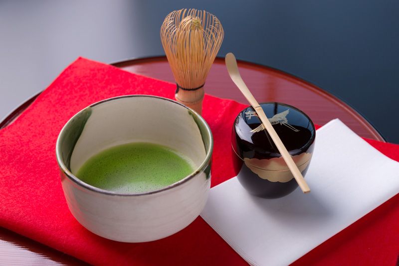 Зліва направо: чайне горнятко тяван, бамбуковий віночок тясен, лакована коробочка з чаєм Нацуме, бамбуковий совочок тясяку